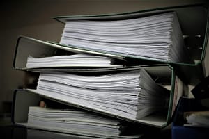 Nosotros 3 Close-up of stacked binders filled with documents for office or educational use.